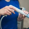 Clinician performing shockwave therapy treatment.
