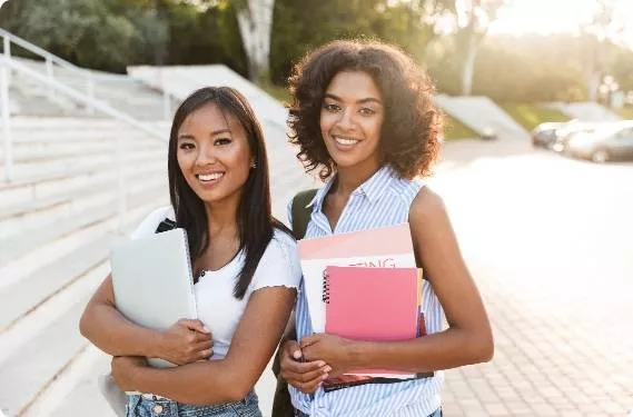 Two female students standing together on steps