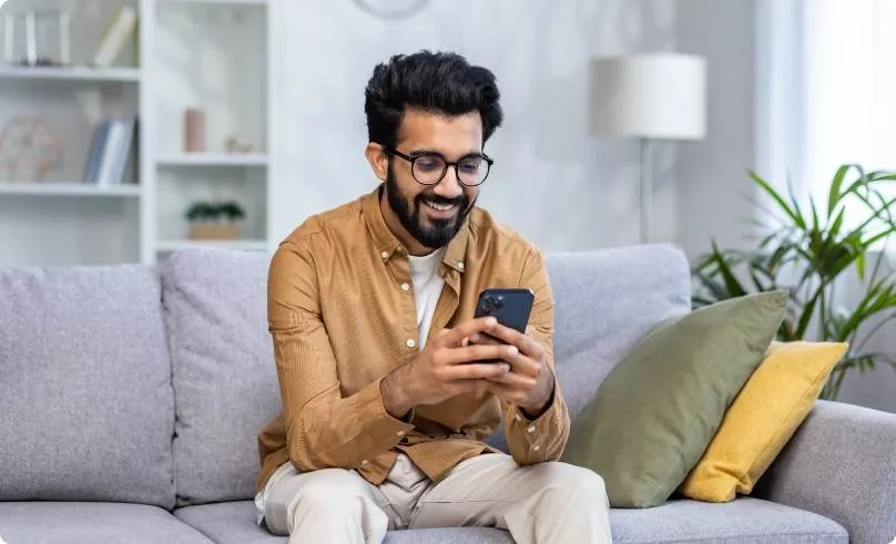 A gentleman sitting on a couch on his phone
