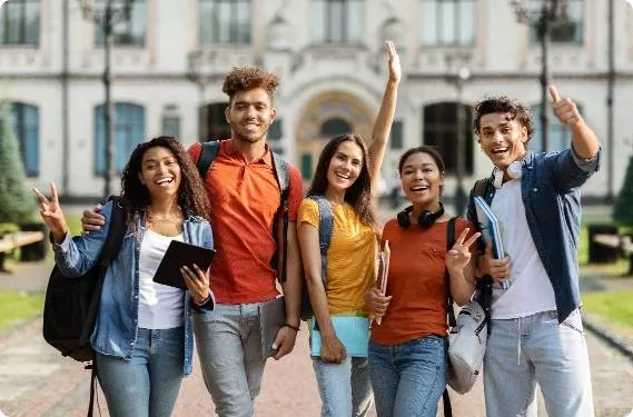 A group of students cheering outside their school with backpacks