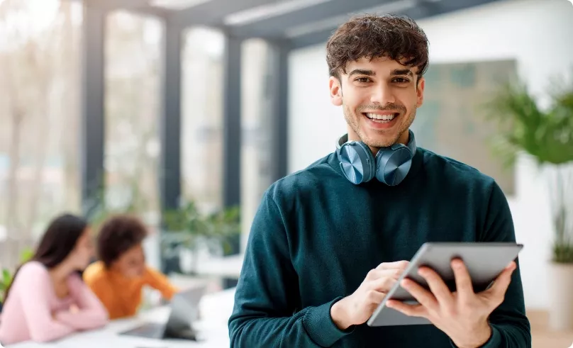 A teenager standing with an ipad