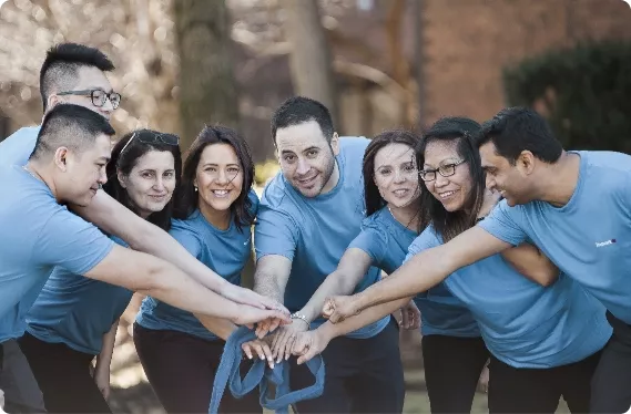 A group of students with their hands in a huddle