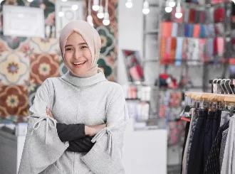 A woman with a hajab standing in front of her shop
