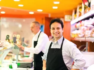 Two men standing in aprons behind the counter