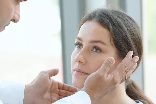 Therapist examining eyes of mature woman