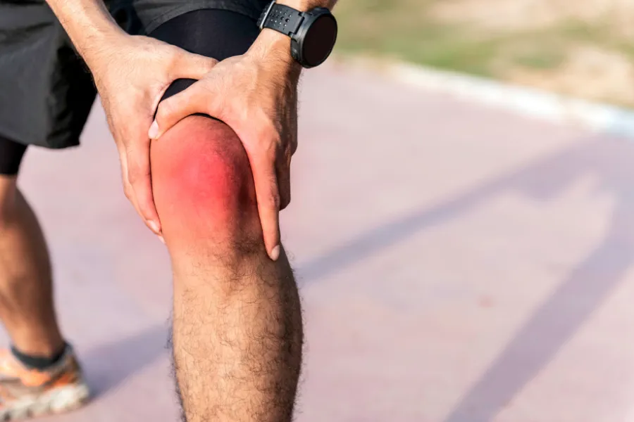 Person holding their knee in pain